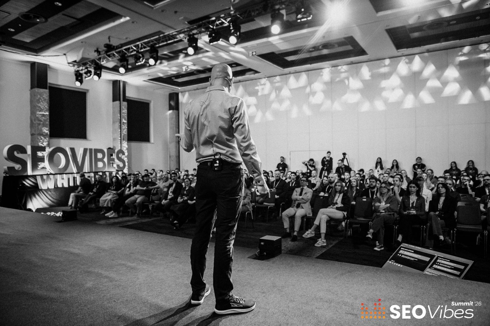 View from behind Stephen Burns on stage, facing a full audience at SEO Vibes Summit 2026